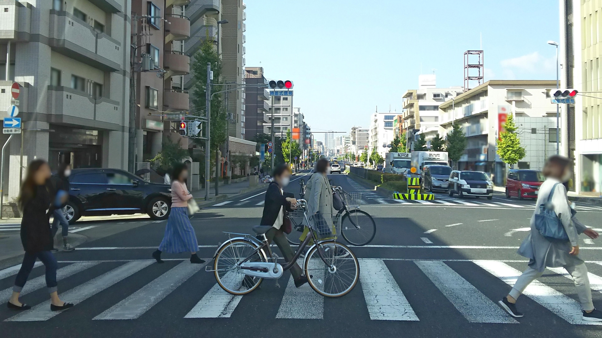 自転車を押して横断歩道を渡る人たち