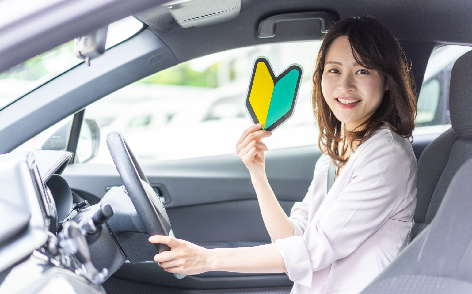 自動車免許取得したばかりで初心者マークを用意している女性
