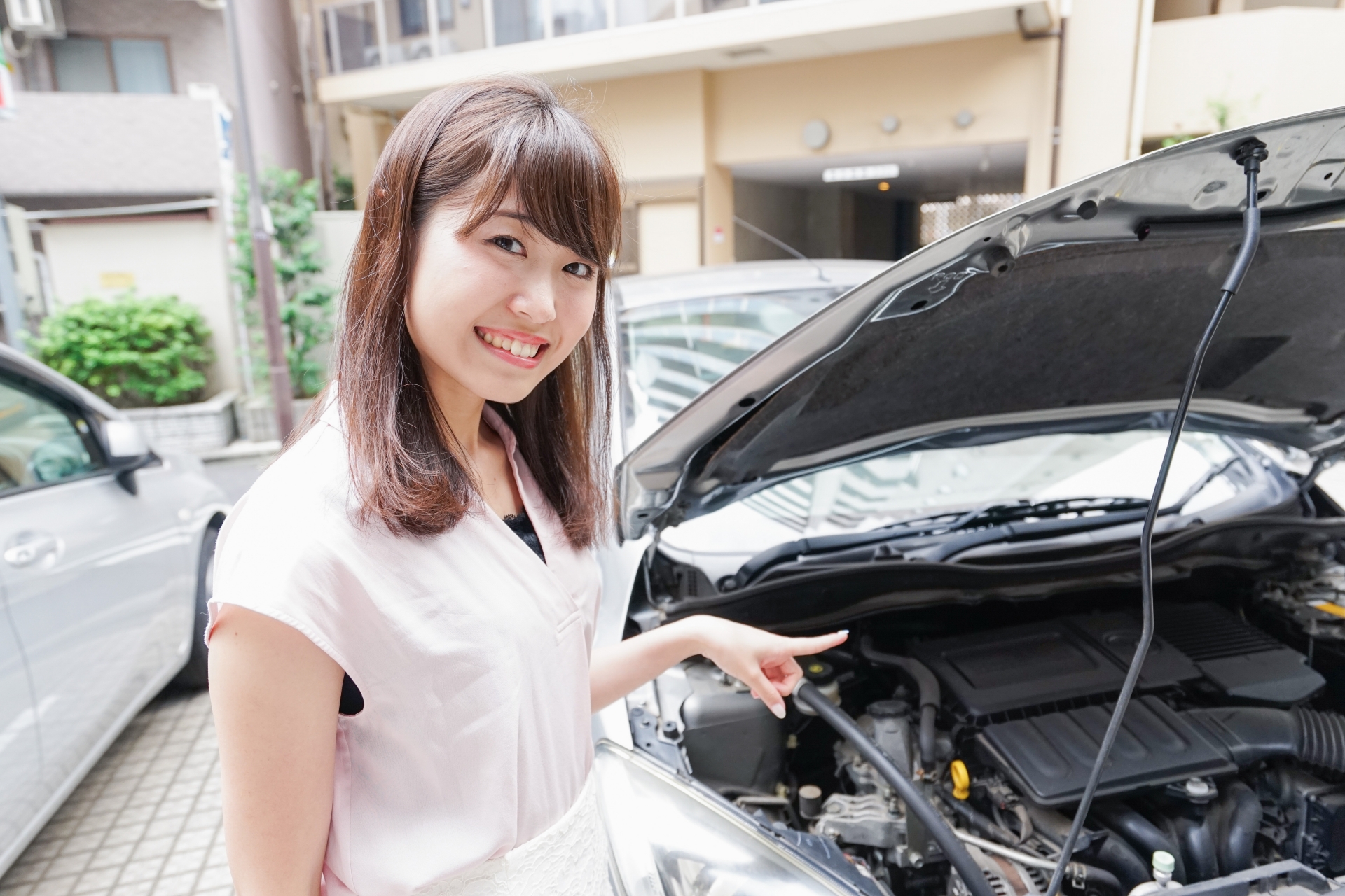 車のメンテナンスをする女性