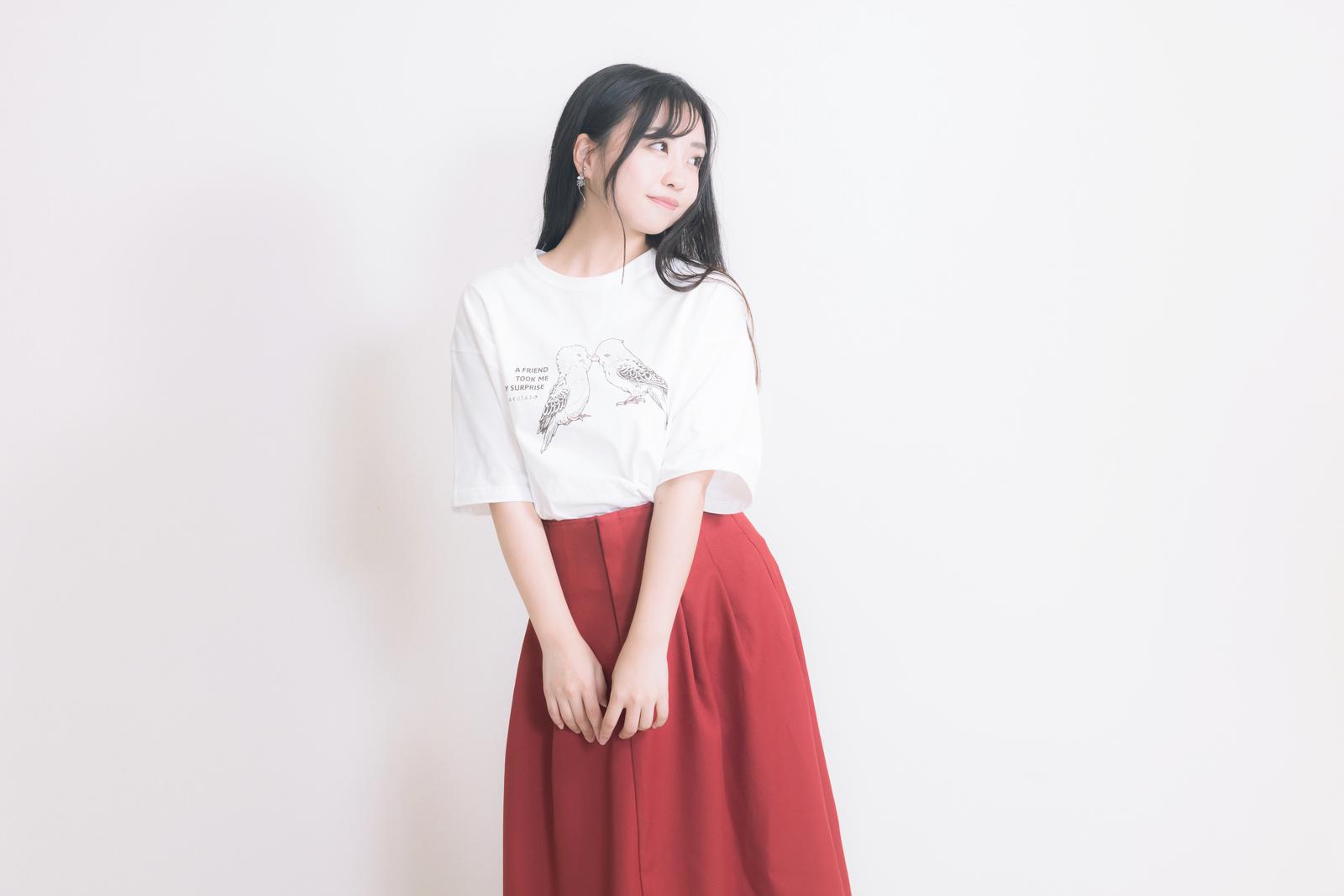 白いTシャツと赤いロングスカートを着た女性。モデル：河村友歌